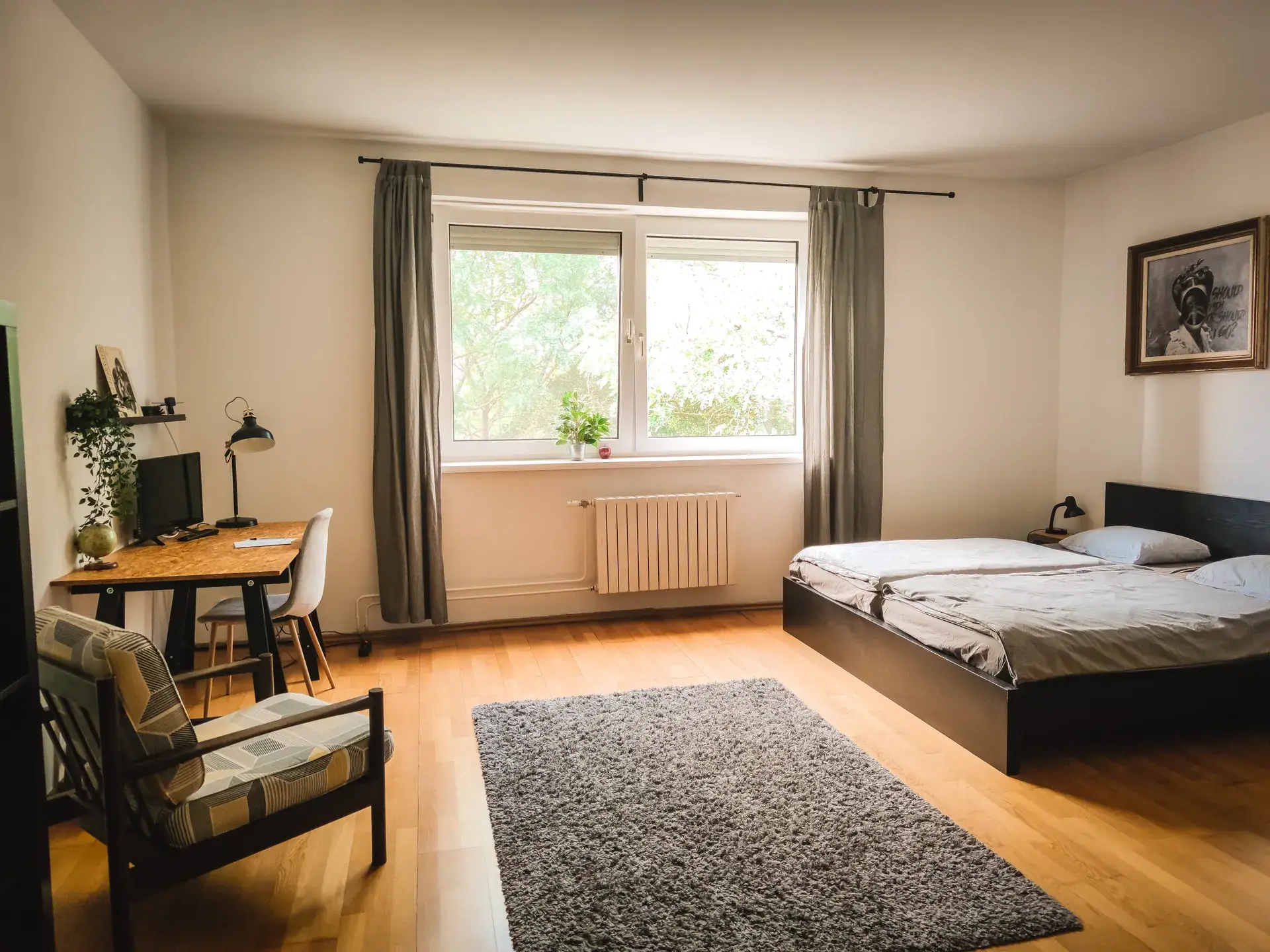 Habitación de estudiante luminosa con cama, escritorio y ventana